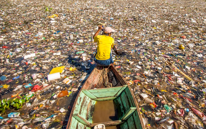 Kuva: Adobe Stock. Mies kerää muoviroskaa Bandungissa Länsi-Jaavalla Indonesiassa. Citarum-joki on yksi maailman pahiten roskaantuneista joista.